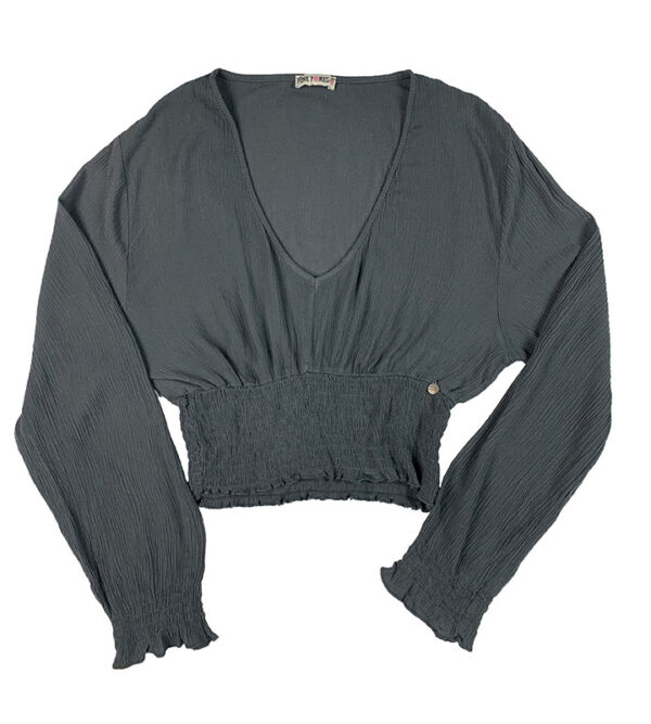 blusa gris con escote pico y fruncida en puños y bajos en tejido bambula y mangas largas.