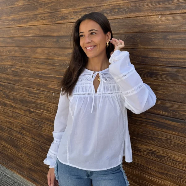chica sonriendo con una blusa blanca y un tejano azul de pink pomelo