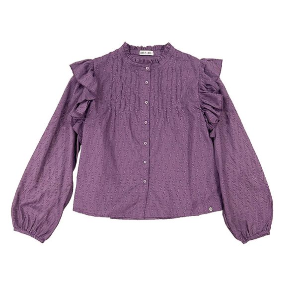 Blusa de color berenjena con botones en el frontal y volantes en los hombros. Forro en el cuerpo y goma elástica en puños. Tejido con detalles bordados