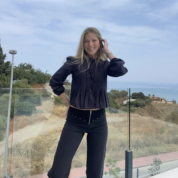 chica posando al aire libre con una blusa de color antracita con tableado en el pecho