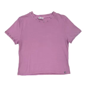 Camiseta rosa con tachuelas plateadas en forma de estrella alrededor de cuello y mangas