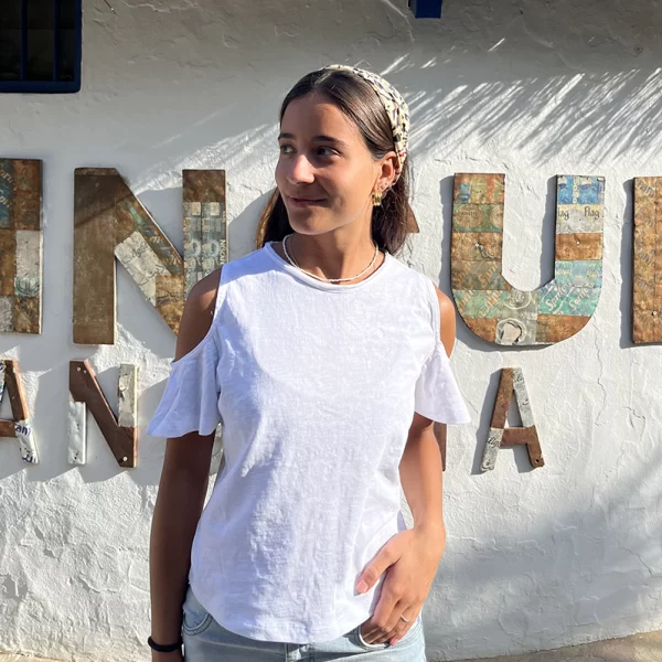 chica con una camiseta blanca de hombros descubiertos pero con manga corta