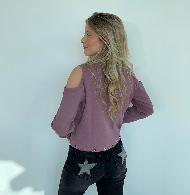 chica de espaldas con camiseta rosa con tachuelas y pantalon negro