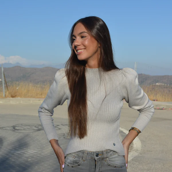 chica sonriendo con un jersey de canalé gris y tejano gris
