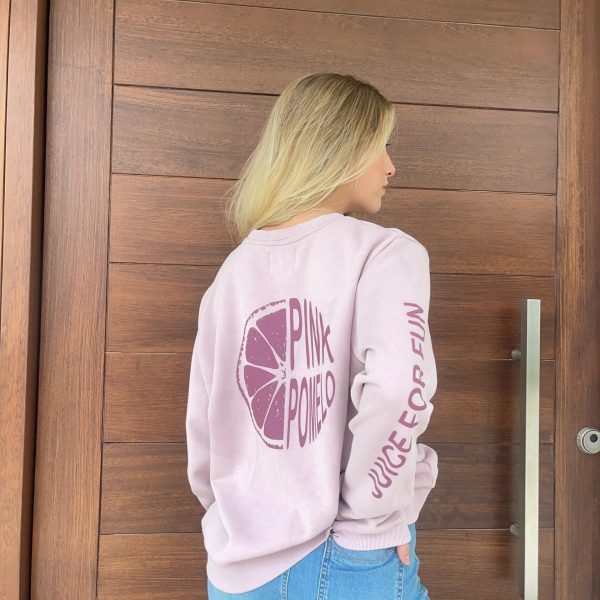 chica de espalda con sudadera rosa con estampado a sobre tono Pink Pomelo y pantalón tejano azul