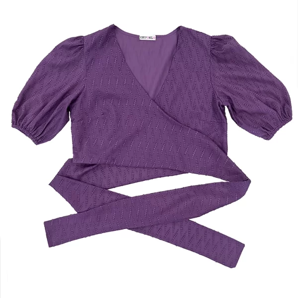 Blusa cruzada tejido fantasía en color berenjena. Manga corta abullonada. Forro interior a tono