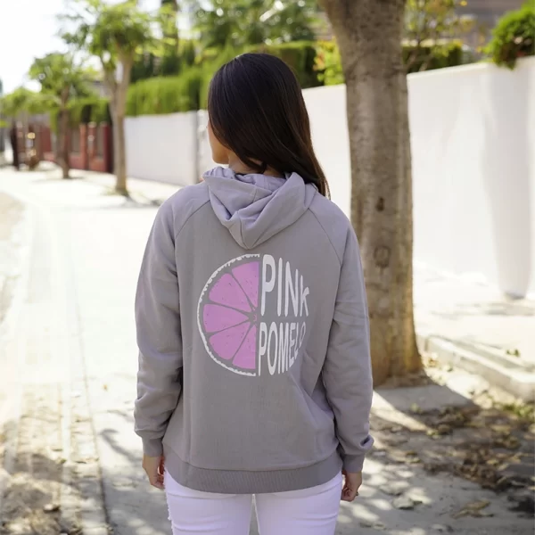 chica de espaldas con una sudadera gris de Pink Pomelo con el estampado del logo en espalda en tonos rosas y blancos y pantalón blanco