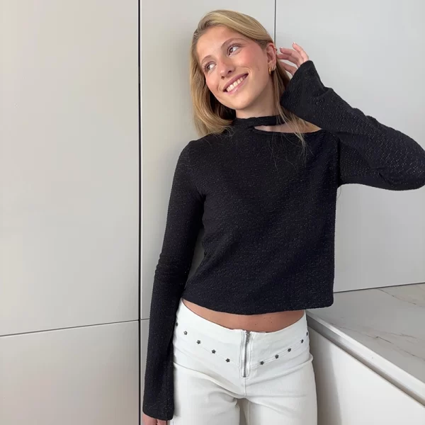 chica rubia posando con un top negro
