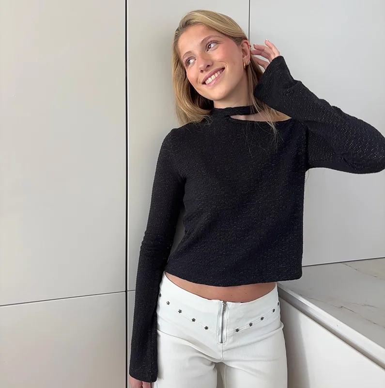 chica rubia posando con un top negro